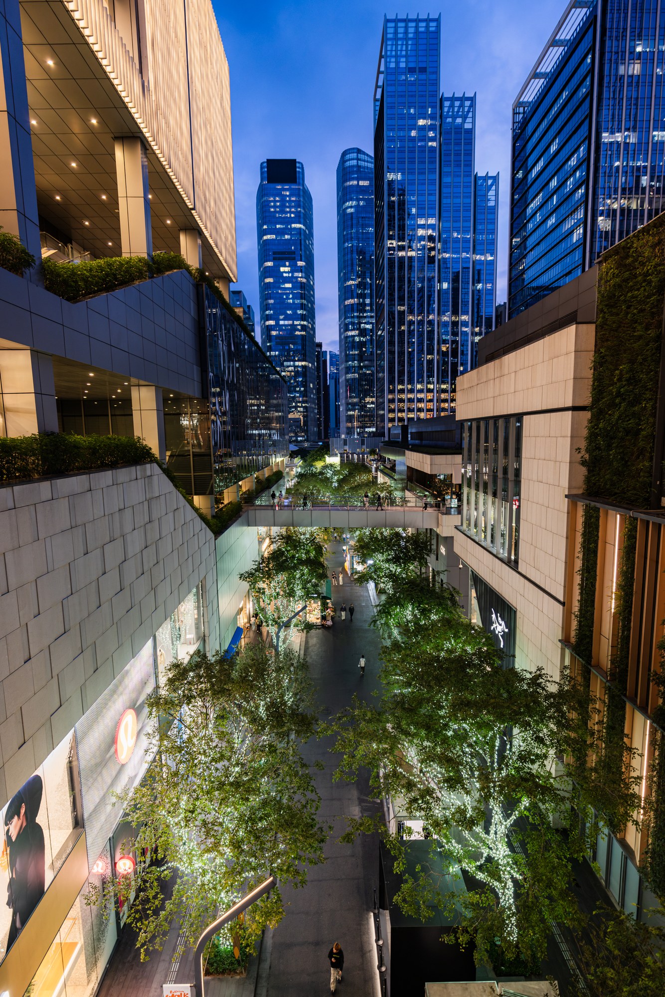 Skyscrapers around a green garden courtyard in the blue hour, China